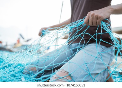 Close up of a young male fisherman preparing a fishing net