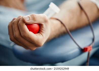 Close Up Of Young Man Donating Blood And Holding Red Ball In Hand, Copy Space