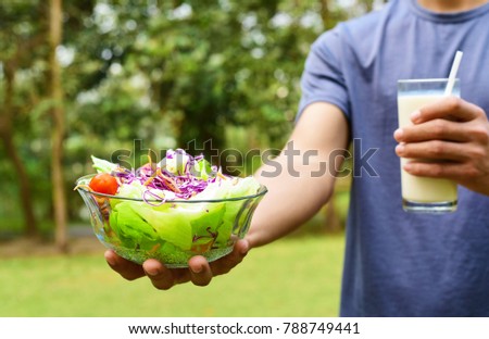 close up young man eating a healthy salad after outdoor exercise