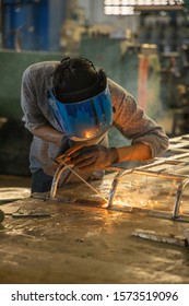 Close Up A Young Man Employee Wearing Welding Mask (protective Mask) Weld A Metal Welding Machine In A Garage. Steel Structure Factory, Industrial Worker , Metal Cutting, Automotive Past.