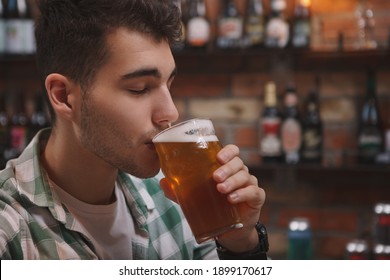Close Up Of A Young Man Enjoying Drinking Delicious Beer At The Pub