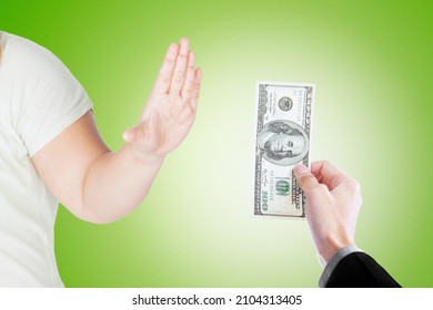 Close up of young man hand refusing bribe money from a businessman while standing in the studio with green screen background - Powered by Shutterstock