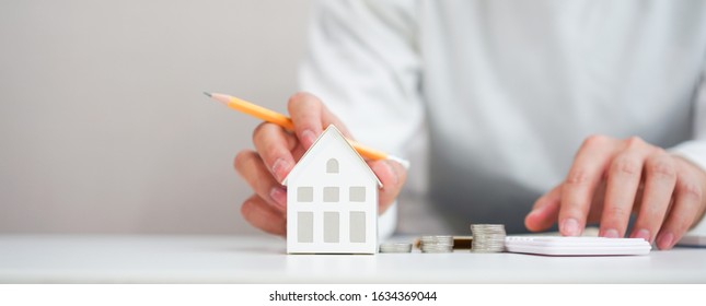 close up young man hand touching house's model for check and summary expense of home loan mortgage for refinance plan , people lifestyle concept - Shutterstock ID 1634369044