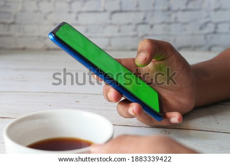 Close up of young man hand using smart phone.