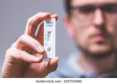 Close up of young man holding express antigen covid test, negative result - Shutterstock ID 1927376000