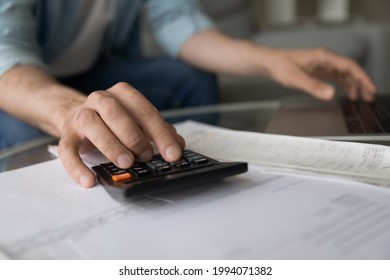 Close up young man managing household budget, calculating domestic expenditures, planning investments or managing savings earnings, paying bills or taxes, financial affairs, accounting concept. - Shutterstock ID 1994071382