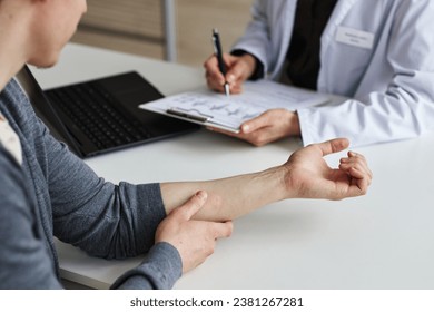 Close up of young man showing skin on forearm during visit to dermatology clinic, copy space - Powered by Shutterstock