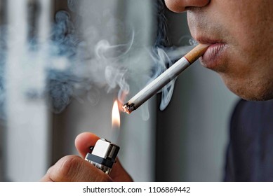 Закройте молодой человек, курящий сигарету.