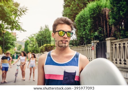 Close up of young man with sunglasses holding surfboard