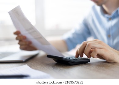 Close up young man using calculator, managing household monthly budget, summarizing taxes or bills, planning future investments, doing financial affairs at home, accounting bookkeeping concept. - Shutterstock ID 2183570251
