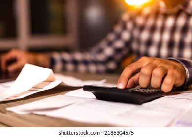 Close up young man using calculator, managing household monthly budget, summarizing taxes or bills, planning future investments, doing financial affairs at home, accounting bookkeeping concept. - Shutterstock ID 2186304575