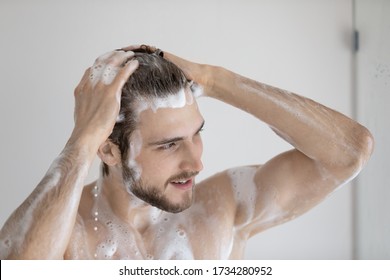 Close Up Of Young Naked Caucasian Man Wash Clean Hair With Foamy Natural Shampoo In Bathroom, Millennial Male Take Morning Shower, Cleansing In Bath, Body Hygiene, Daily Routine Concept