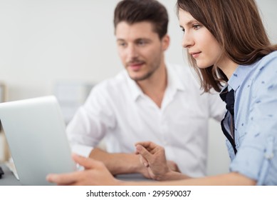 Close Up Young Office Couple Looking At The Laptop Screen On The Table Together With Serious Facial Expressions.