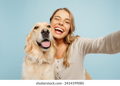 Close up young owner woman with her best friend retriever dog wear casual clothes do selfie shot on mobile cell phone wink isolated on plain pastel light blue background. Take care about pet concept