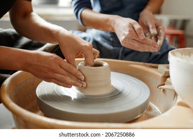 Close up young people working on pottery wheel together in handmade ceramics workshop, copy space - Powered by Shutterstock