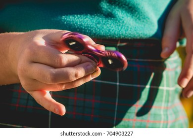 close up of young school girl's hands playing with a fidget spinner toy  - Powered by Shutterstock