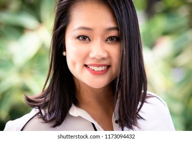 Close Up Of A Young  Singaporean Business Woman Against A Background Full Of Leaves