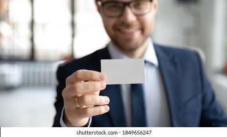 Close up young smiling confident businessman showing blank mock up empty name card to camera, giving personal professional contact information to client, self -introduction acquaintance concept. - Powered by Shutterstock