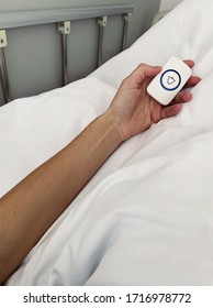 Close Up Of Young Woman Arm With Medical Emergency Alert Button On White Sheet Stock Photo