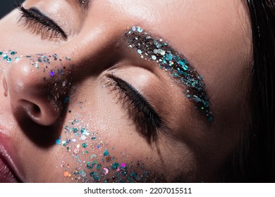 close up of young woman with closed eyes and glitter on face isolated on grey - Powered by Shutterstock