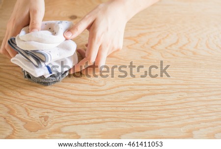 Close up young woman hand folded socks in living room at home,