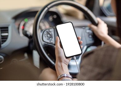 Close Up Of Young Woman Hand Using Mobile Phone In The Car. Mock Up.