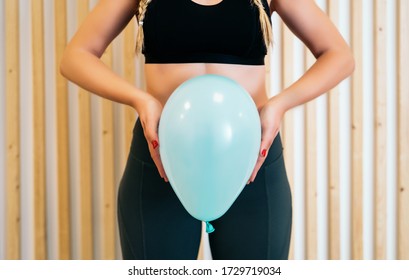Close up of a young woman holding a balloon to explain the diaphragm zones, core and pelvic floor. Pelvic floor exercises explained