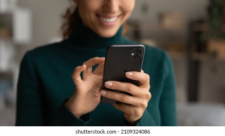 Close up young woman holding cellphone in hands, playing mobile games, shopping in internet store, web surfing information, communicating distantly, ordering food or taxi online, tech addiction. - Powered by Shutterstock