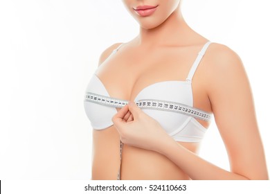 Close up of young woman measuring size of her jugs