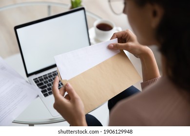 Close Up Young Woman Opening Envelope With Letter, Feeling Curious Of Getting News. Back Rear View Millennial Lady Receive Postal Mail With Important Document, Invitation Or Bank Notification.