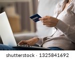Close up young woman shopping online, ordering, paying with credit card, using laptop, sitting on sofa at home, girl holding plastic card in hand, internet bank service concept