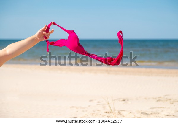 Close Up Of Young Woman Taking Off Her Bra At Nude Beach Concept Of
