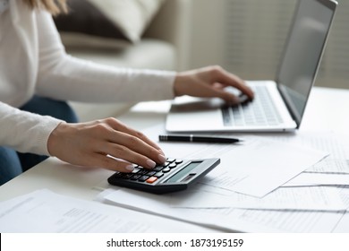 Close Up Young Woman Using Calculator And Laptop, Checking Domestic Bills, Sitting At Table With Financial Documents, Managing Planning Budget, Accounting Expenses, Browsing Internet Service