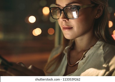 Close Up Of Young Woman Wearing Glasses Using Cellphone In Office. Businesswoman Texting On Her Smart Phone.