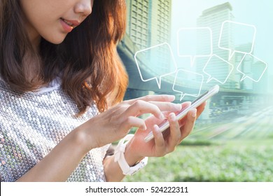close up younger woman touching on smart phone screen and quotes bubble floating against city building background