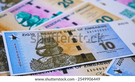close up of Zimbabwe gold zig notes spread on table. Paper money currency scattered on surface as background