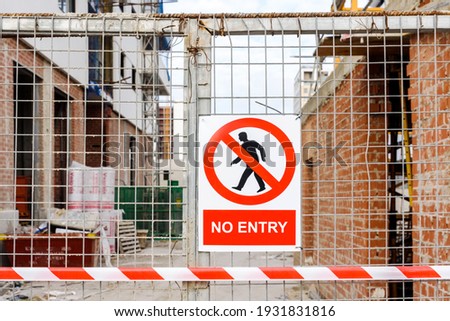 Closed access door to the construction site of a building, with a no-entry sign.