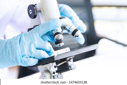 Closed Up Asian Woman Scientist, Researcher, Technician, Or Student' Hand Conducting Research Or Experiment By Using Microscope, The Scientific Equipment In Medical, Chemistry Or Biology Laboratory