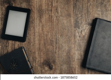 A Closed Bible, An Ebook, And A Notebook On A Wooden Texture. Bible Study Desk