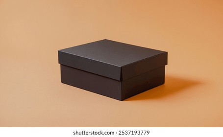 Closed black cardboard box sits on an orange background. Premium packaging box mockup for displaying a marketing advertisement for a product.