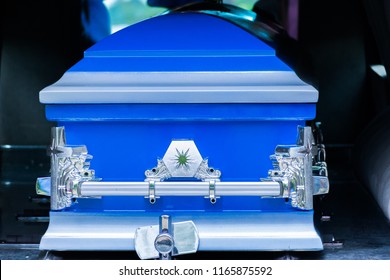 Closed Blue And Silver Coffin/casket In Back Of Hearse Before Cemetery Burial