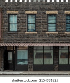 Closed Brown Stone Building With A Red Tin Awning
