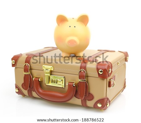 Closed brown suitcase with piggy bank on top of it