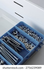 A closed cardboard toolbox and an open plastic box for storing small bolts and nuts 