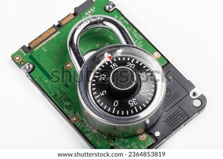 Closed code padlock laying on top of a HDD hard drive, object detail, closeup, disk data encryption, files locker password protection user data safety policies, cyber security abstract concept, nobody
