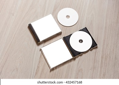 Closed Compact Disc Template With Plastic Box Case With White Isolated Blank For Branding Design And Open Box With Booklet. CD Jewel Mock Up With Clean Free Space On Wooden Table. Perspective View