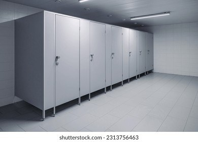 Closed cubicle doors in a public restroom. Public toilet cubicles. Clean toilet, view from inside the room