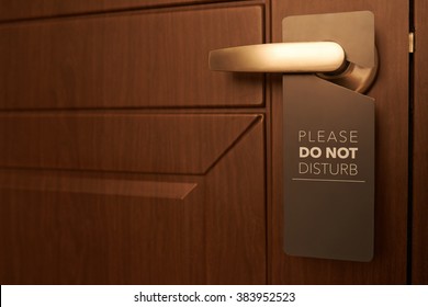 Closed door of hotel room with please do not disturb sign - Shutterstock ID 383952523