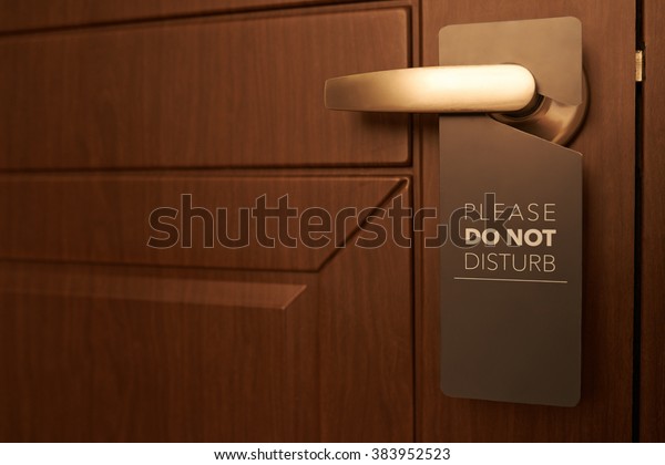 Closed
door of hotel room with please do not disturb
sign