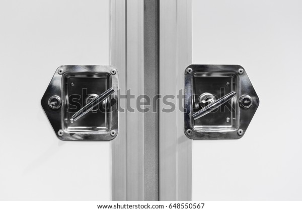 Closed doors of cargo truck, handle and lock of delivery\
vehicle with white bodywork, commercial transport industry, detail\

